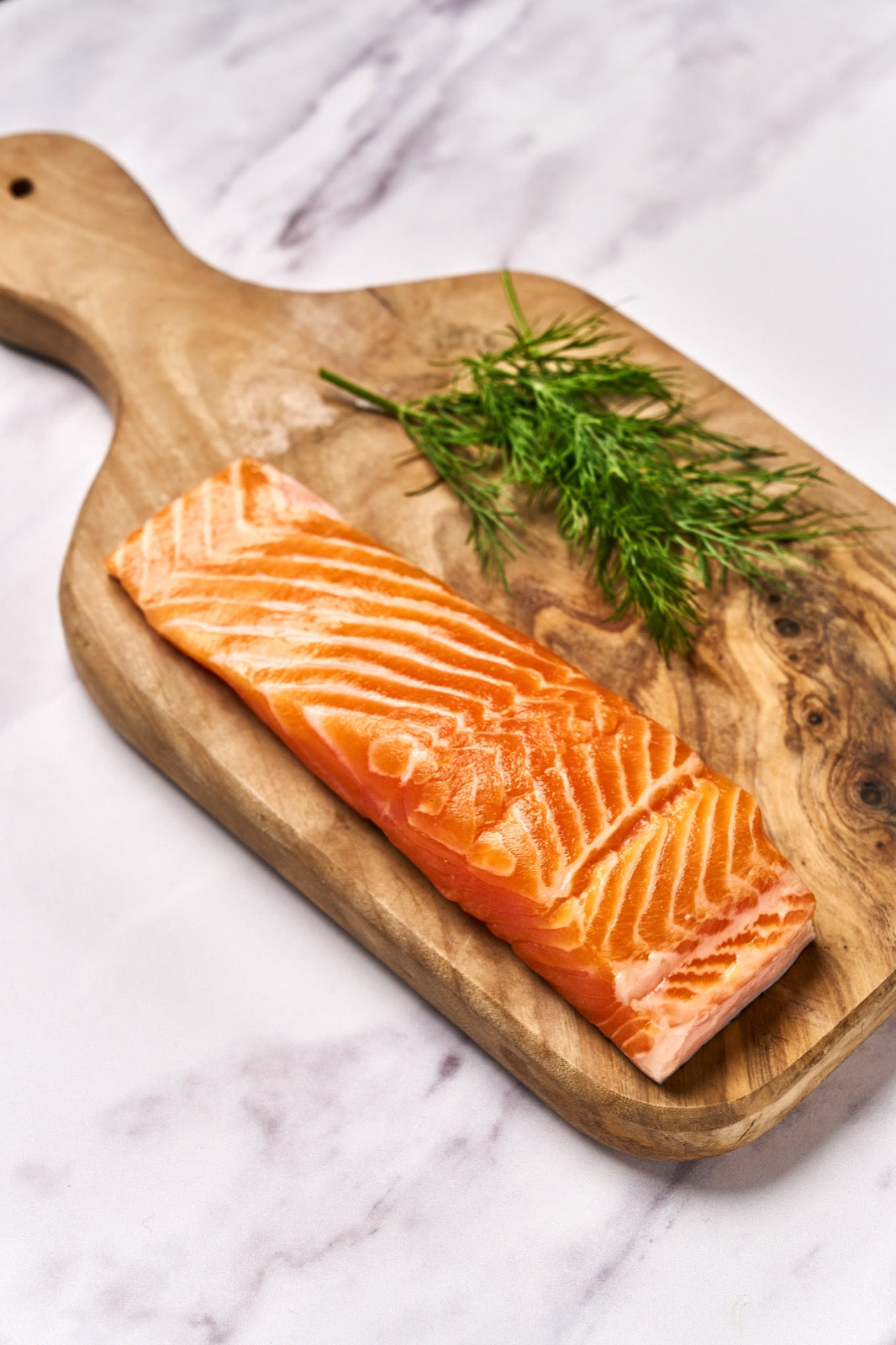 A portion of Chalk Stream Trout fillet from Rockfish Online Seafood Market on a wooden board