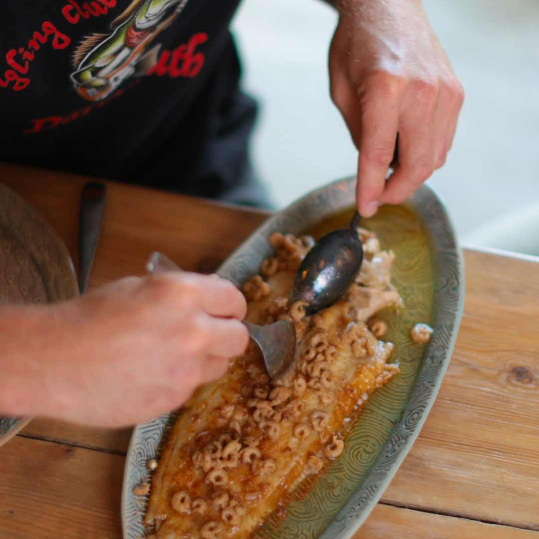 Alfie filleting a cooked Dover Sole meuniére with morecambe shrimp butter in the quayside kitchen