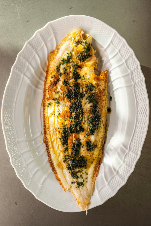 A cooked Dover Sole Meunière on a white plate