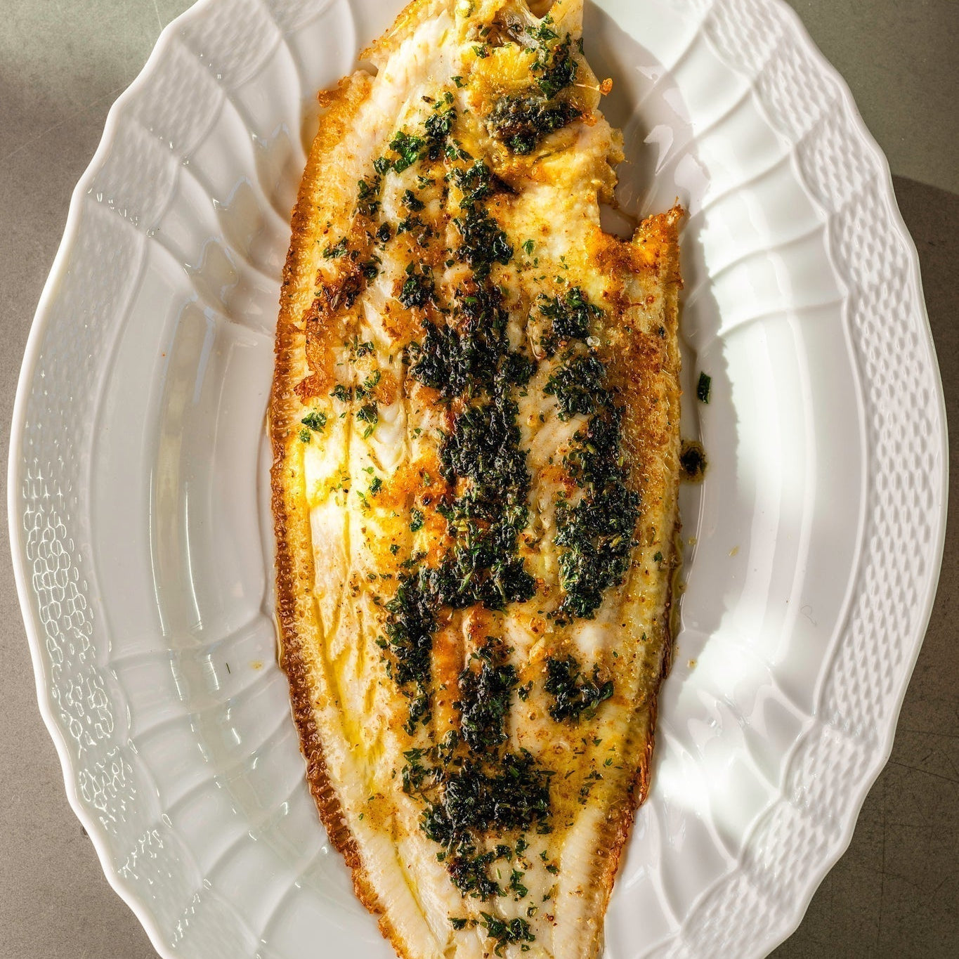 A cooked Dover Sole Meunière on a white plate