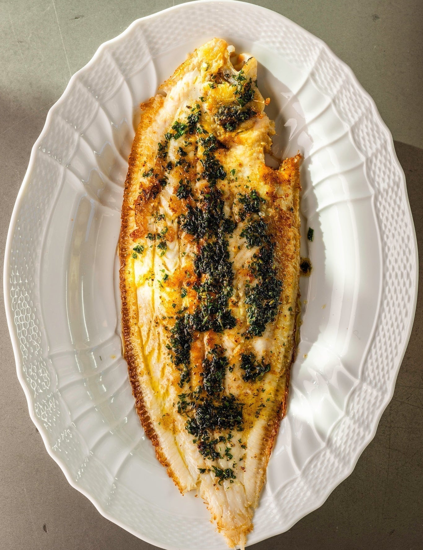 A cooked Dover Sole Meunière on a white plate