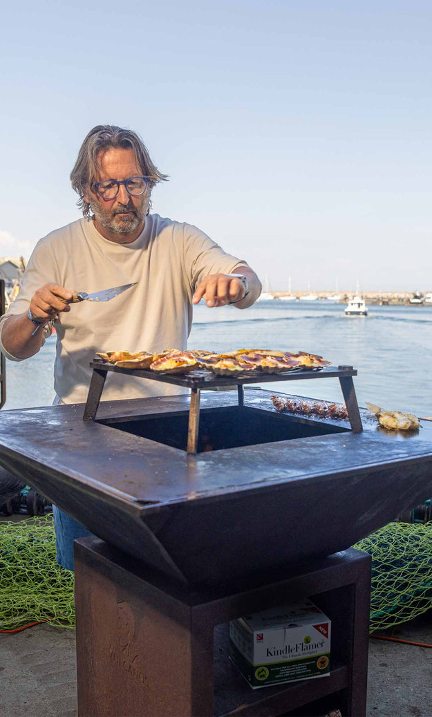 Mitch cooking on a Vulcanus BBQ in front of Brixham harbour