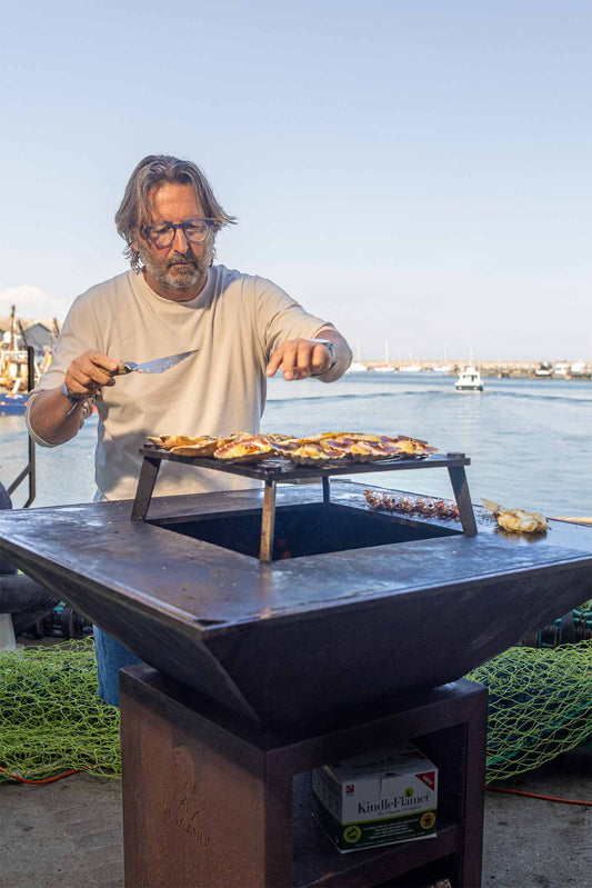 Mitch cooking on a Vulcanus BBQ in front of Brixham harbour