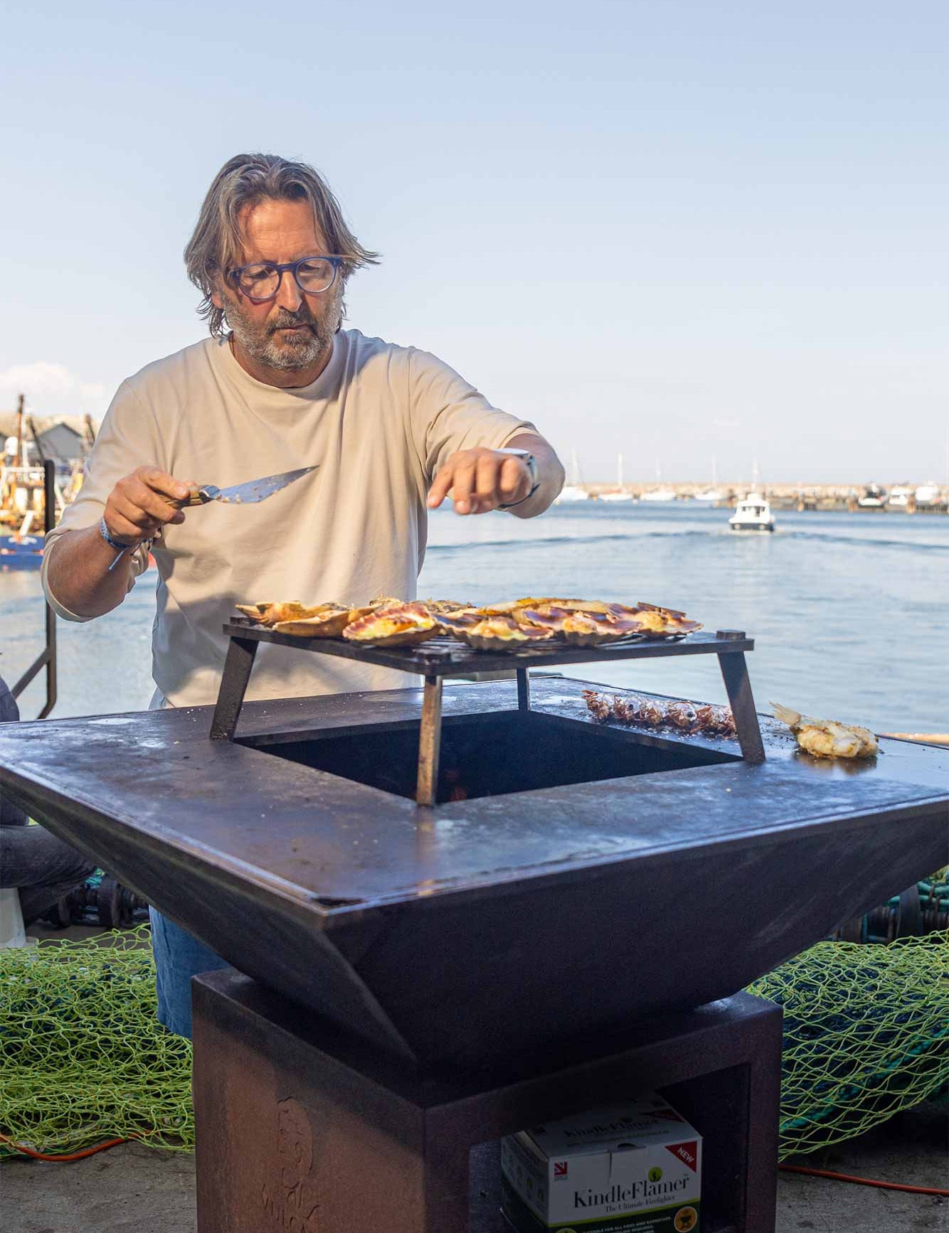 Mitch cooking on a Vulcanus BBQ in front of Brixham harbour