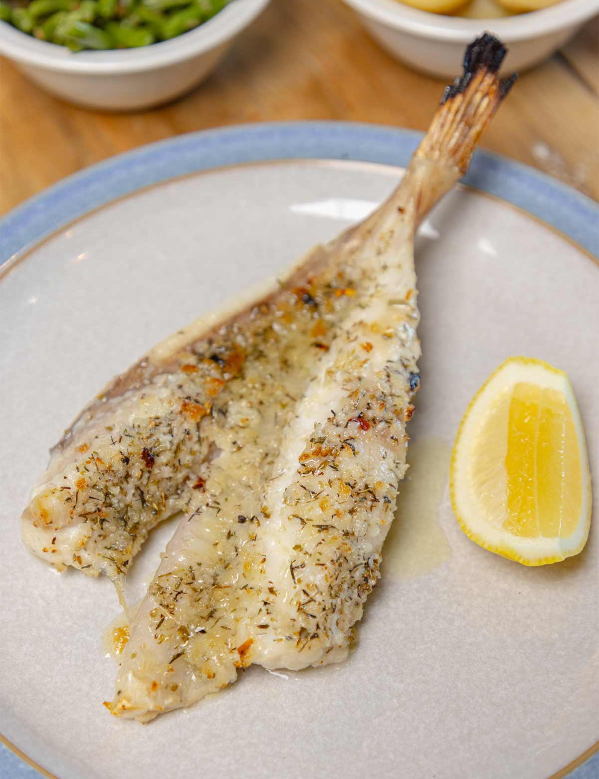 Monkfish as grilled in Romagna by Rockfish on a table with green beans and new potatoes in the top of the frame