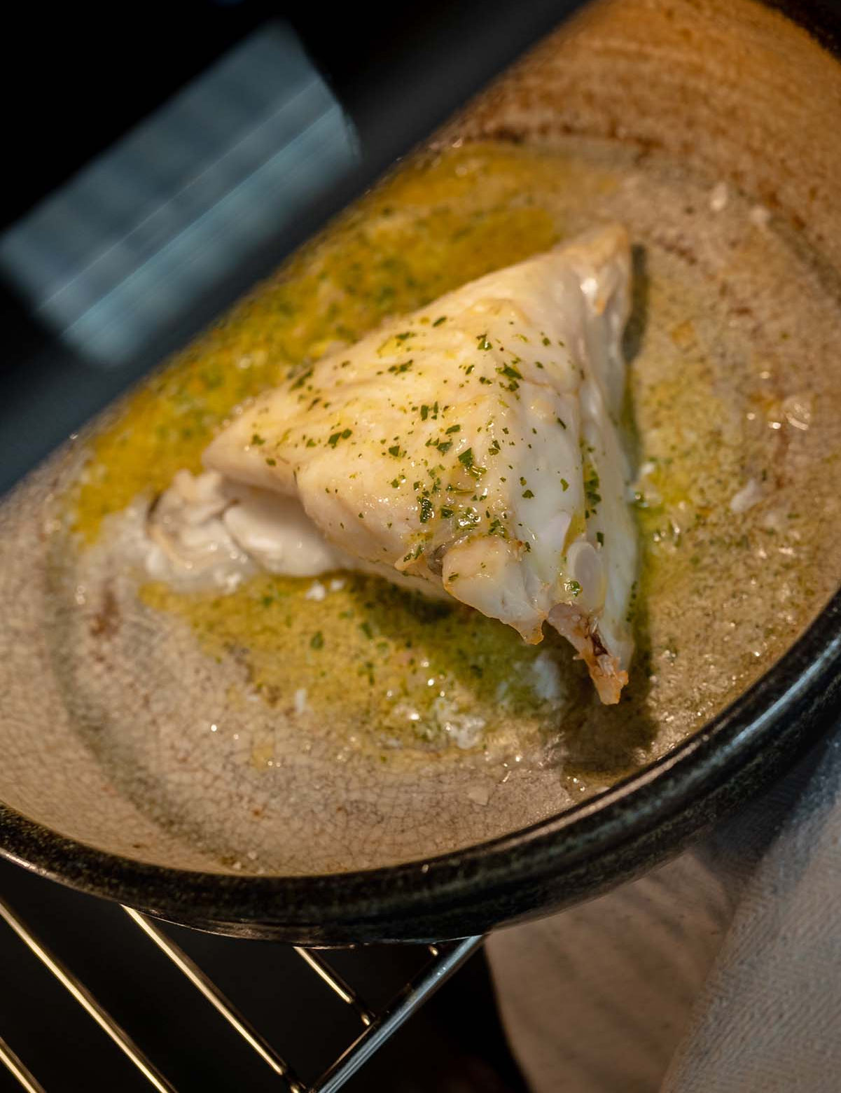 Piece of Turbot being cooked in an oven with garlic butter