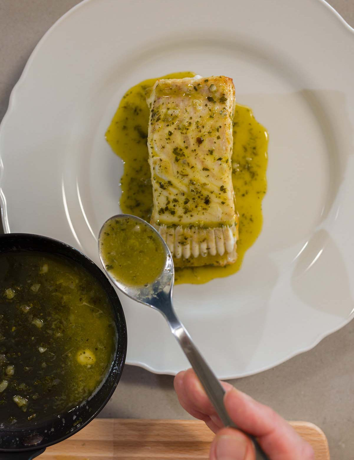Turbot T-Bone on a plate being finished with butter