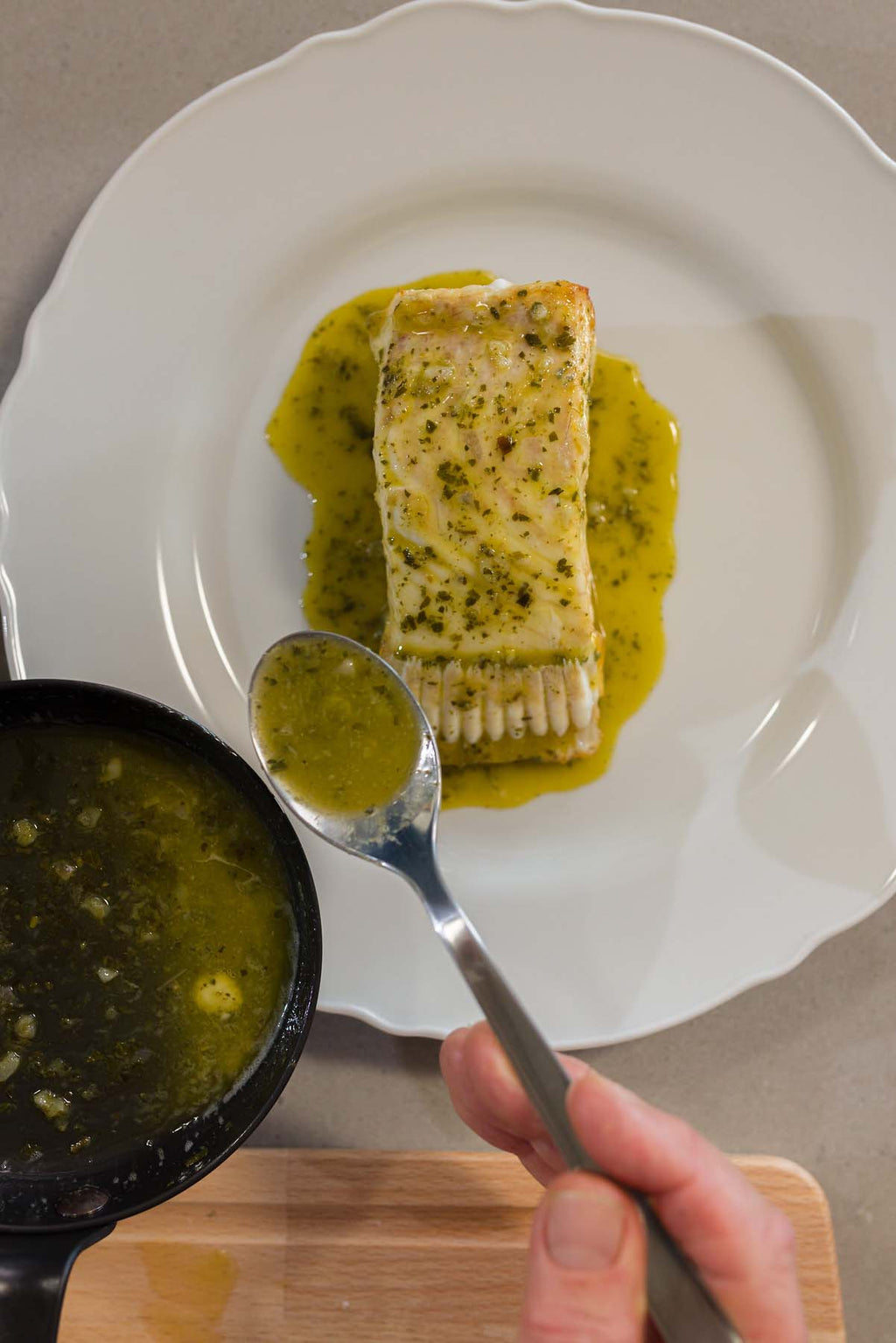 Turbot T-Bone on a plate being finished with butter