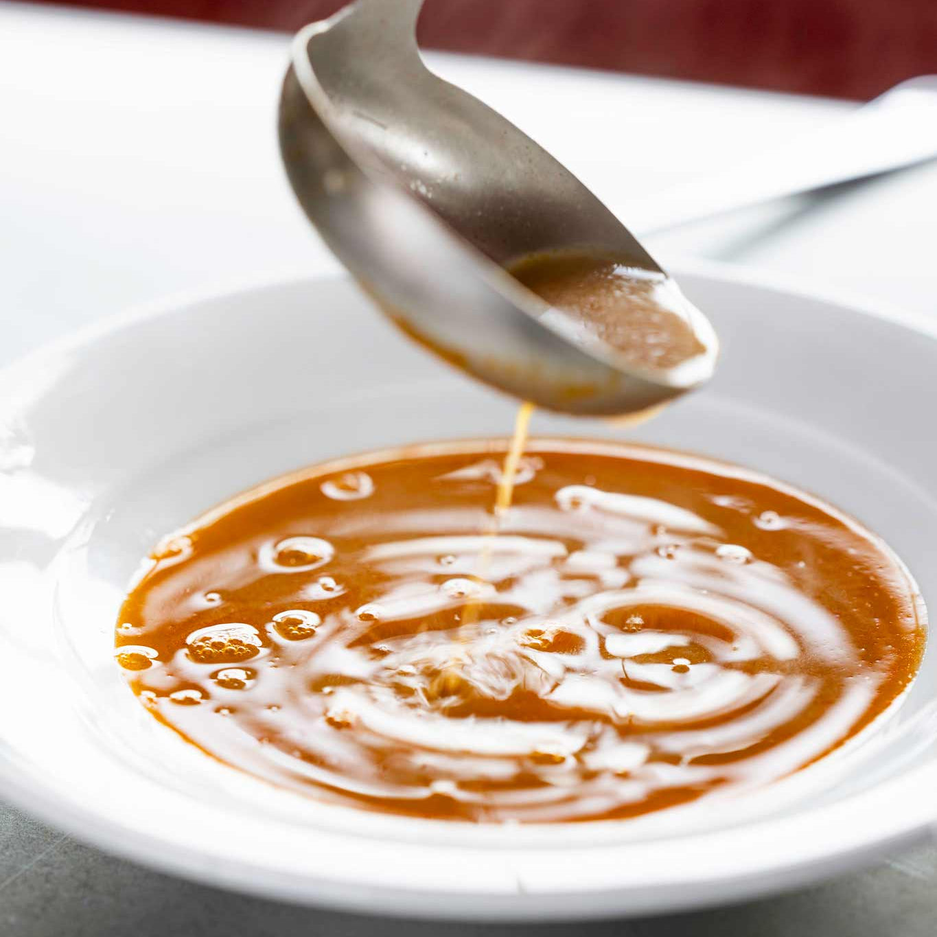 Shellfish bisque being ladled into a bowl