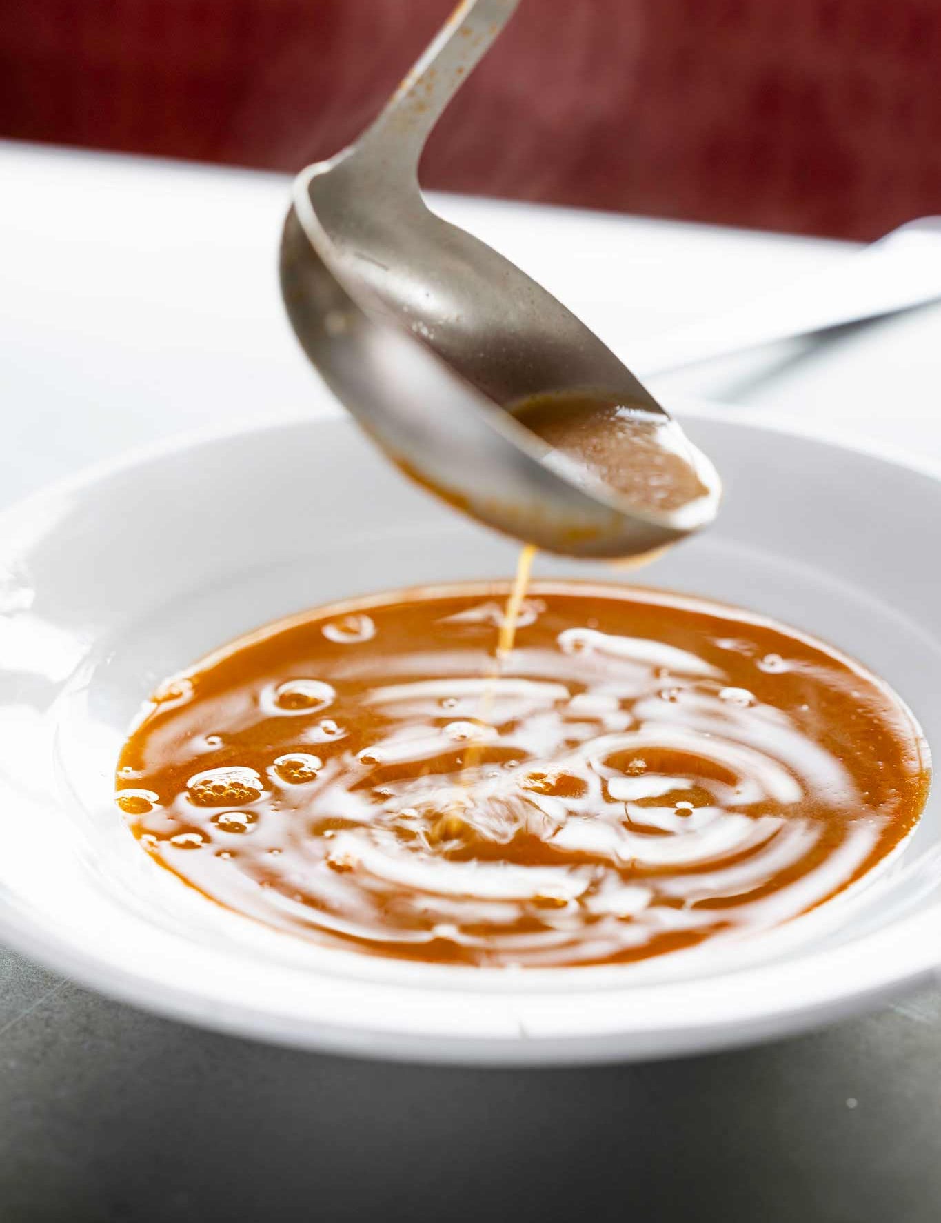 Shellfish bisque being ladled into a bowl