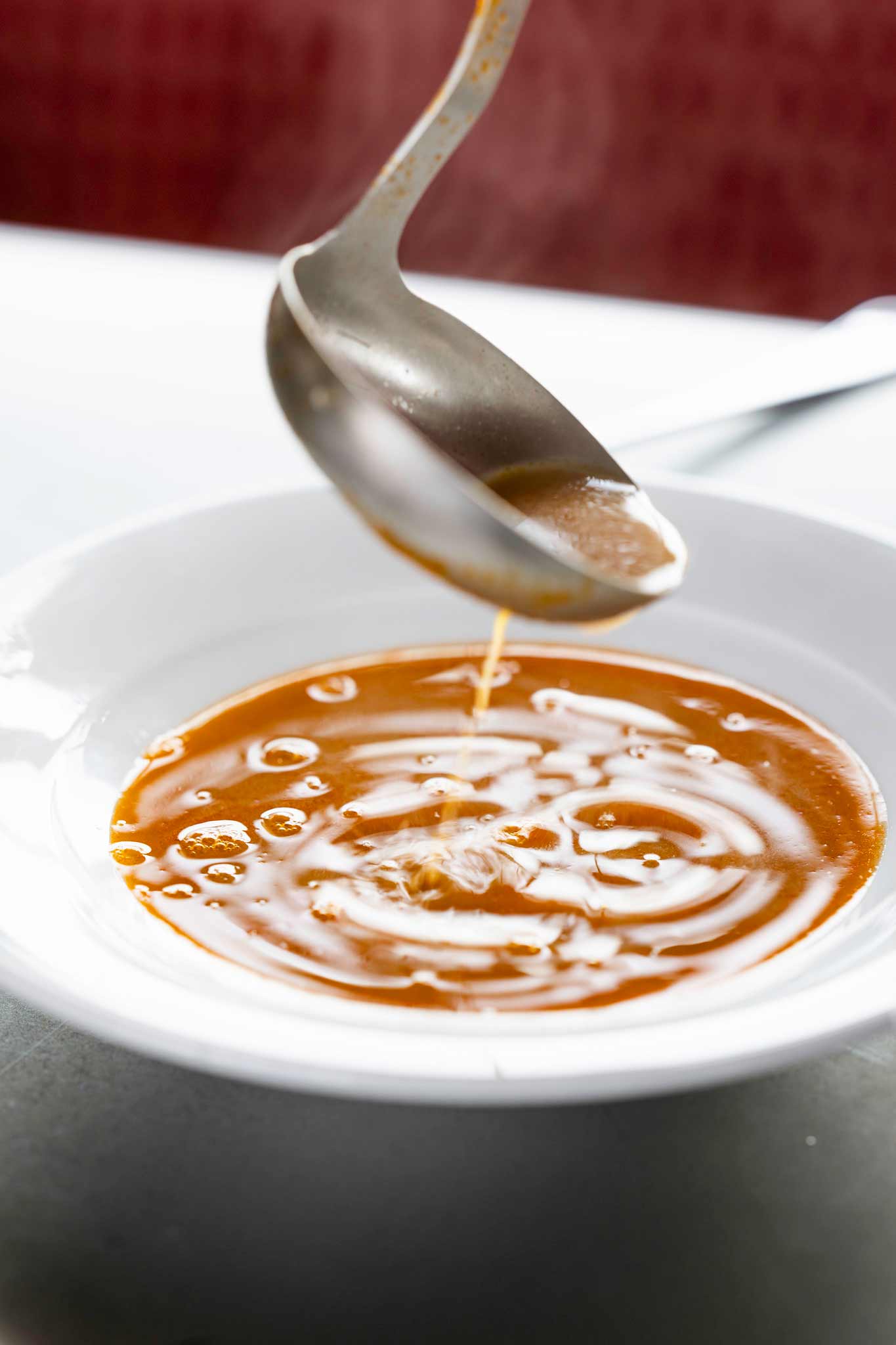 Shellfish bisque being ladled into a bowl