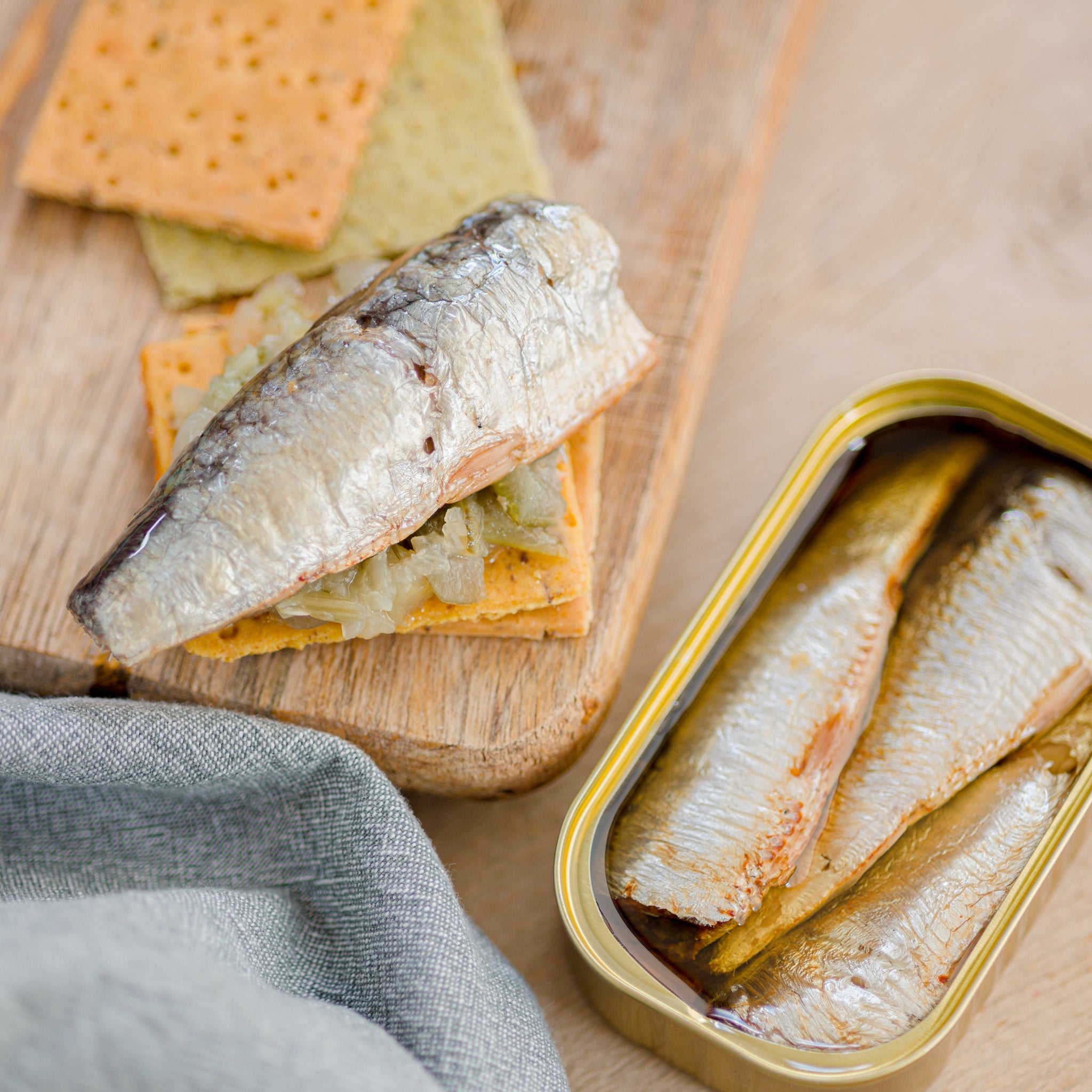 Tin of Sardines with a sardine fillet on a cracker
