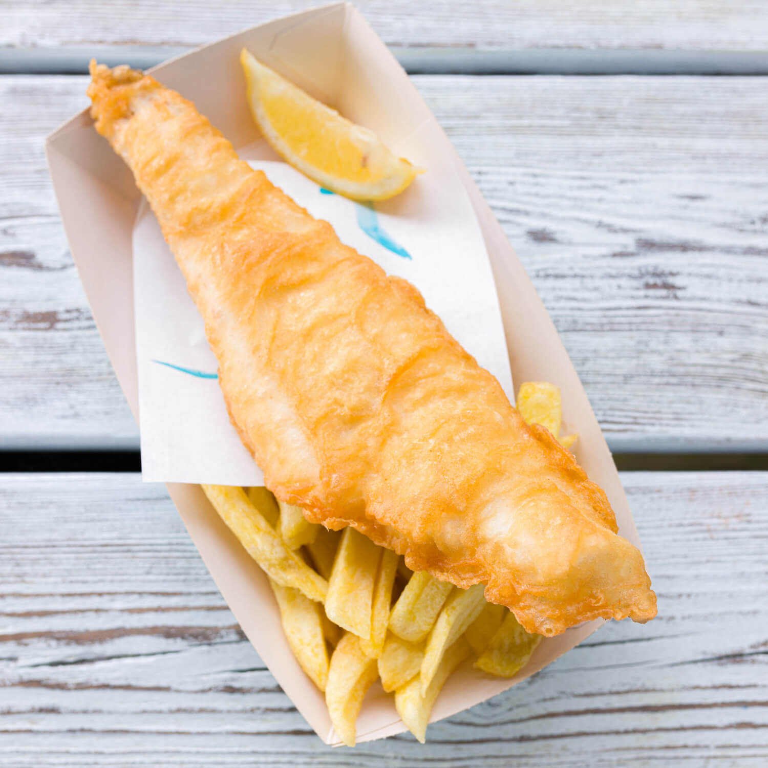 Portion of Rockfish takeaway fish & chips with a wedge of lemon