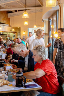 People dining at a Rckfish restaurant with a server and patrons in the background.