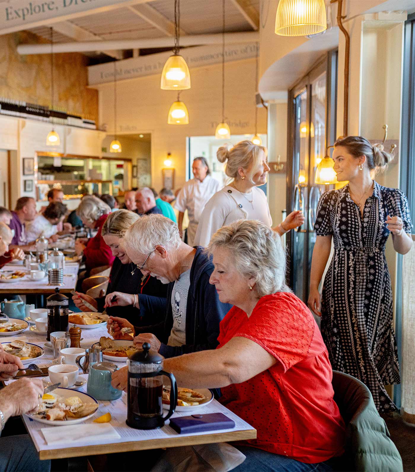 People dining at a Rckfish restaurant with a server and patrons in the background.