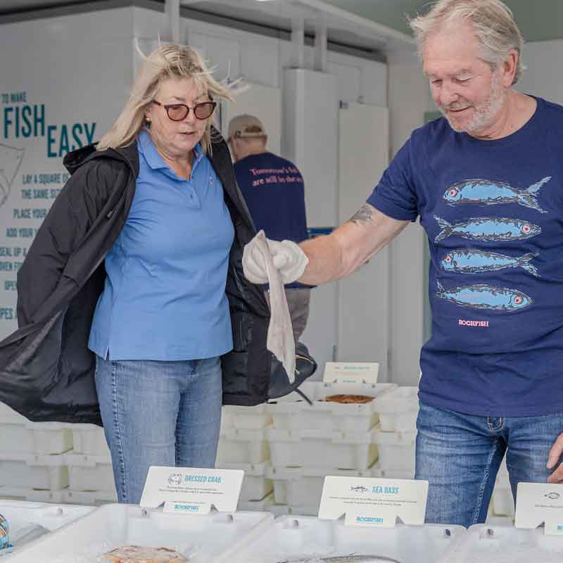 Brixham Rockfish fish market staff serving a customer