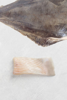 A portion of halibut from Rockfish delivered nationwide the next day sits under the whole fish