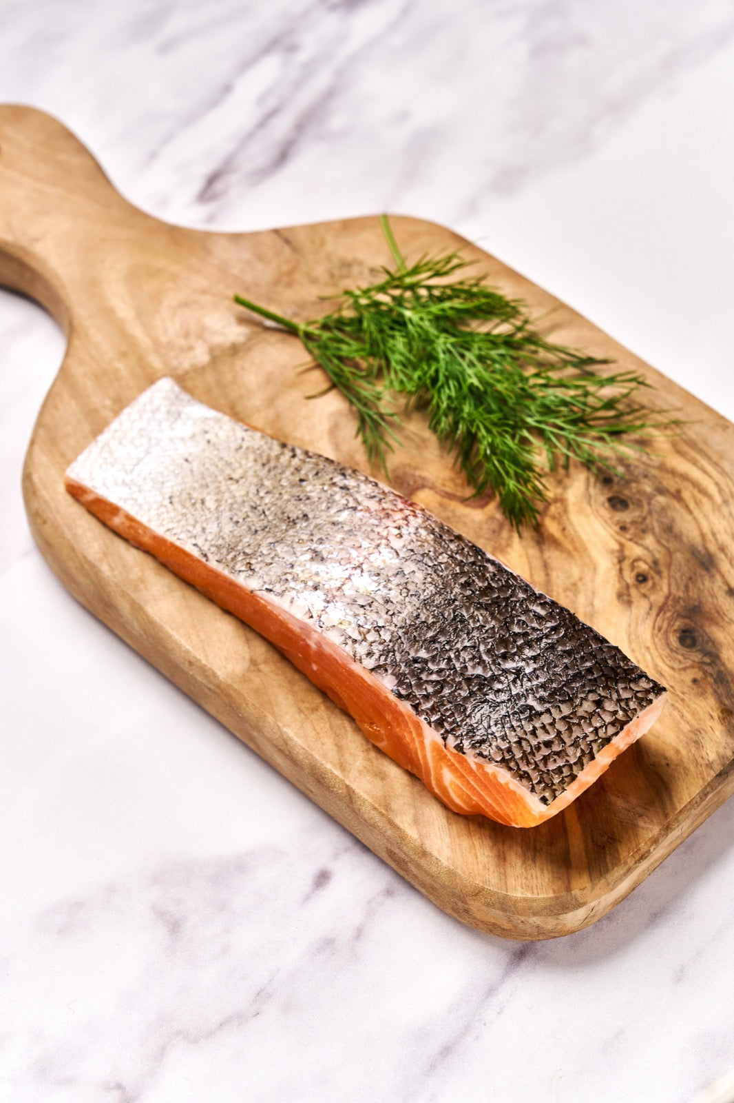 A portion of Chalk Stream Trout fillet from Rockfish Online Seafood Market on a wooden board