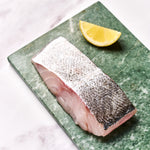 A portion of Coley fillet from Rockfish Online Seafood Market on a piece of marble.