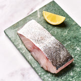 A portion of Coley fillet from Rockfish Online Seafood Market on a piece of marble.