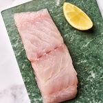 A portion of Coley fillet from Rockfish Online Seafood Market on a piece of marble.