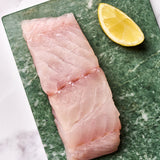 A portion of Coley fillet from Rockfish Online Seafood Market on a piece of marble.