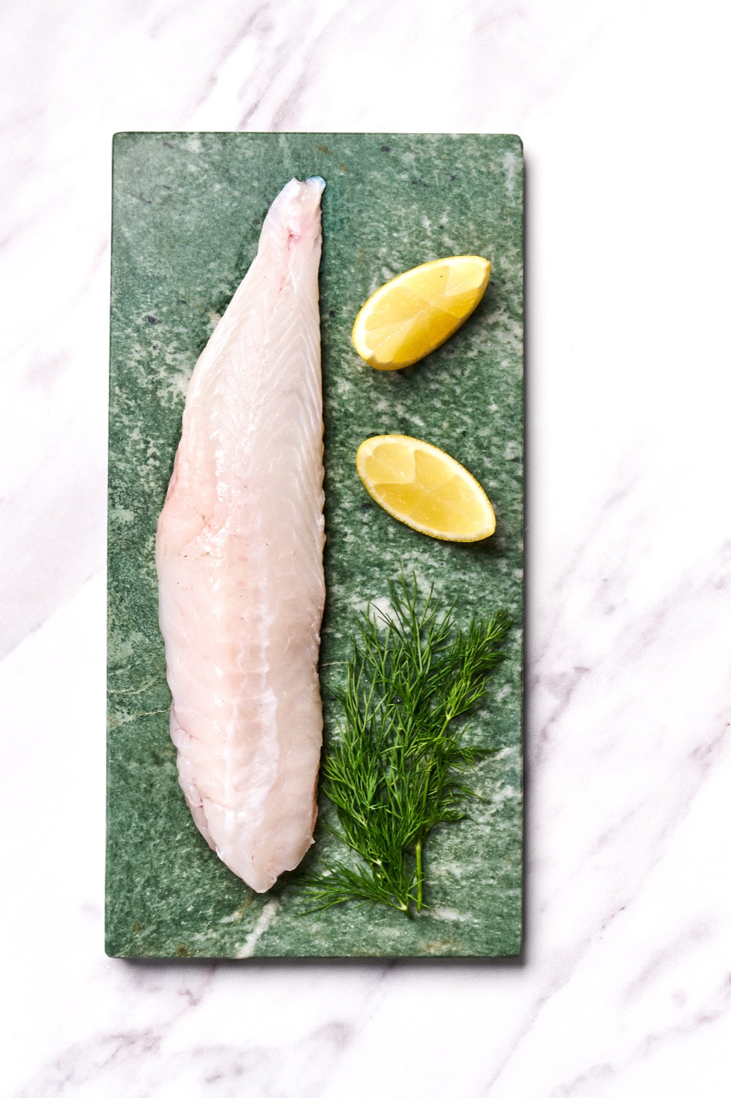 A portion of Monkfish fillet from Rockfish Online Seafood Market on a bpiece of marble