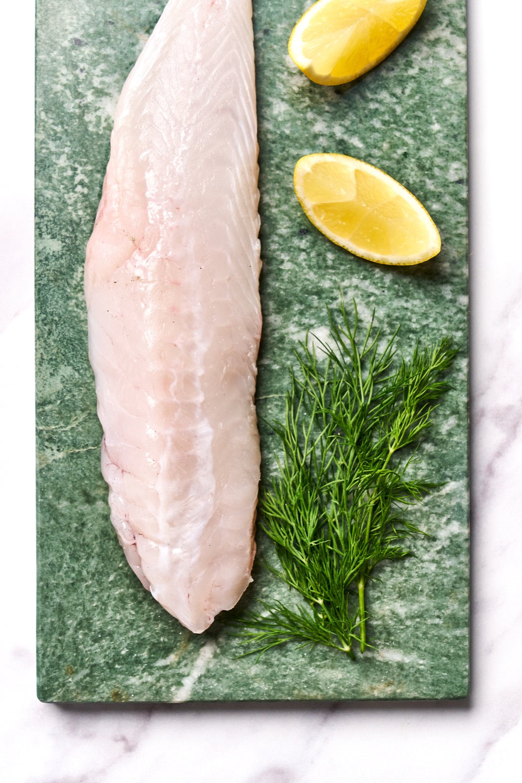 A portion of Monkfish fillet from Rockfish Online Seafood Market on a piece of marble