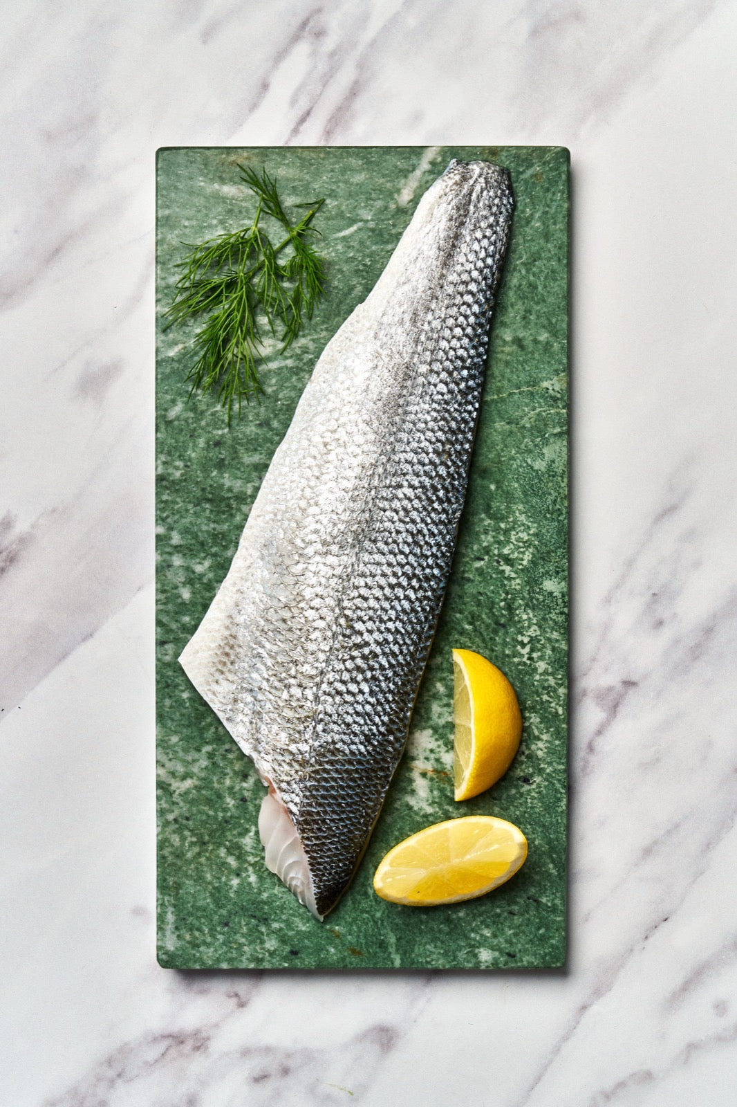 A portion of Seabass fillet from Rockfish Online Seafood Market on a piece of marble