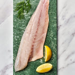 A portion of seabass fillet from Rockfish Online Seafood Market on a piece of marble