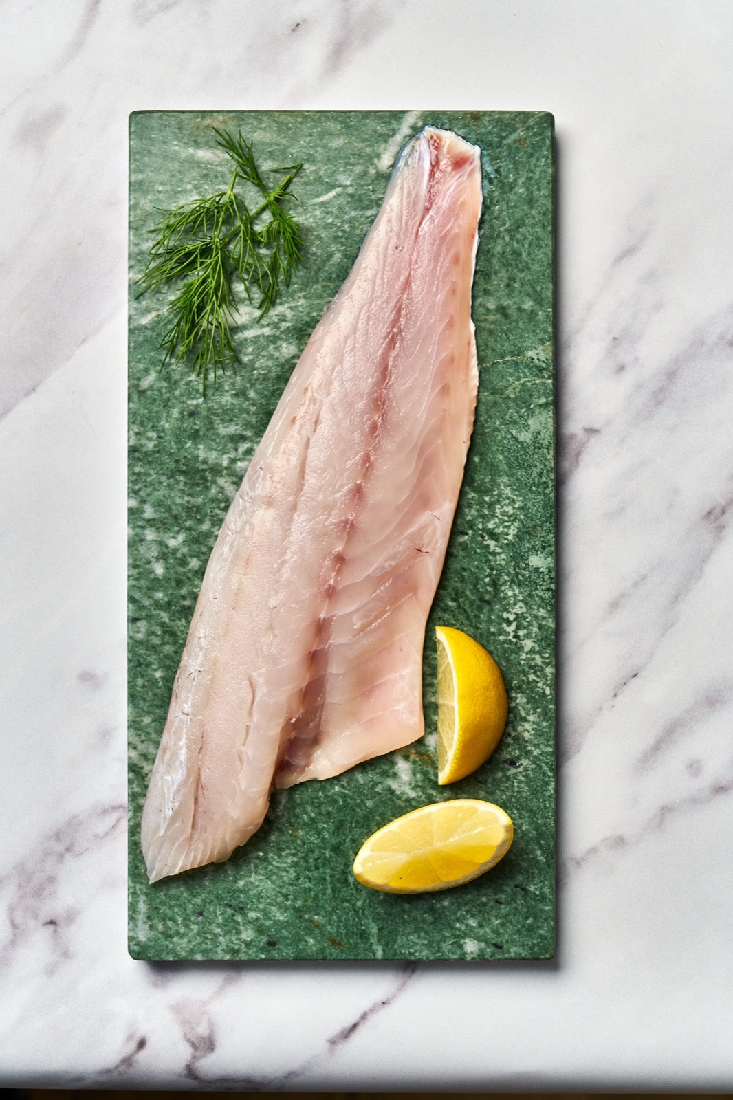 A portion of seabass fillet from Rockfish Online Seafood Market on a piece of marble