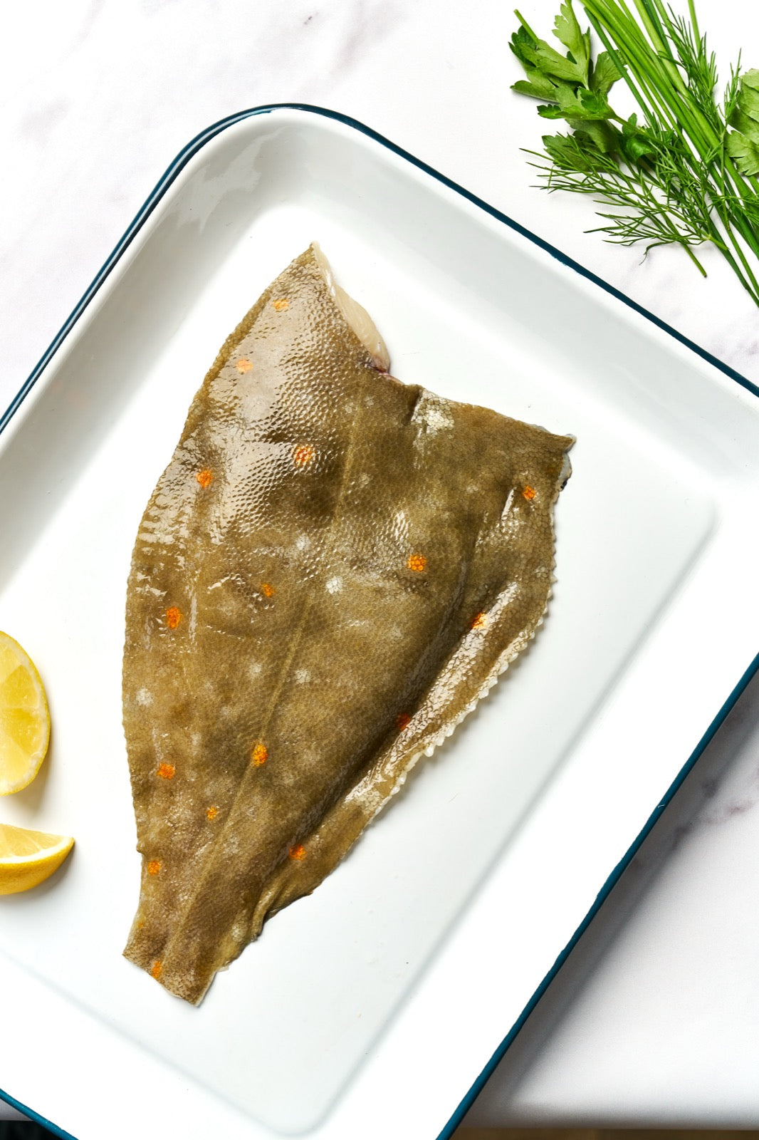 A portion of Plaice fillet skin side up from Rockfish Online Seafood Market on a baking tray