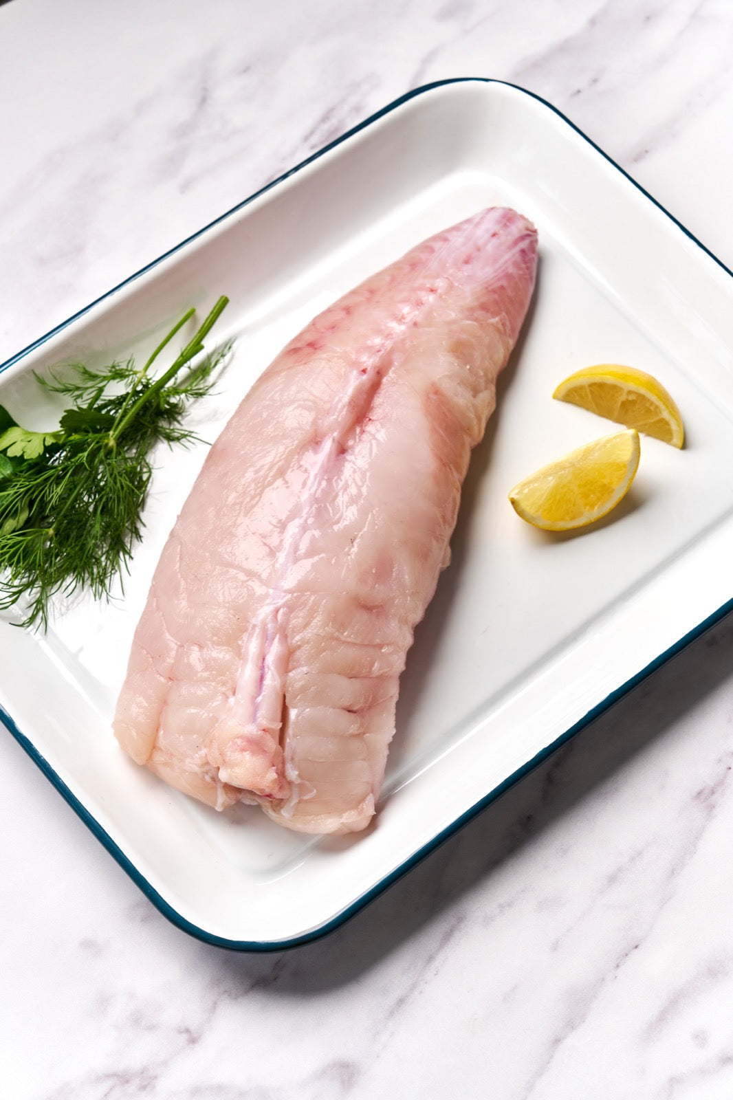 A portion of whole Monkfish tail from Rockfish Online Seafood Market on a baking tray