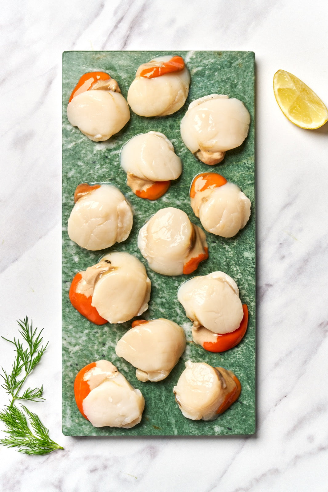 A portion of scallop meat from Rockfish Online Seafood Market on a piece of marble