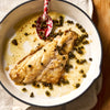 A portion of Black Bream fillet from Rockfish Online Seafood Market cooked in plan surrounded by capers and butter.