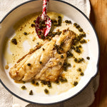 A portion of Black Bream fillet from Rockfish Online Seafood Market cooked in plan surrounded by capers and butter.