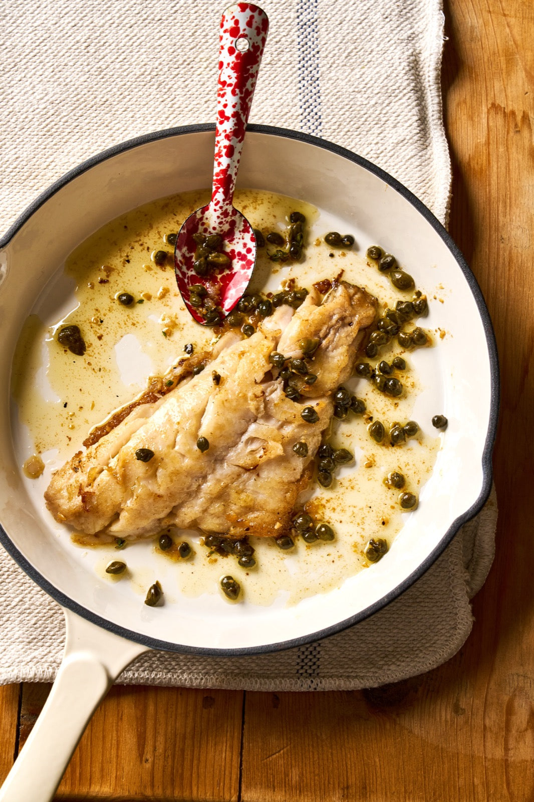 A portion of Black Bream fillet from Rockfish Online Seafood Market cooked in plan surrounded by capers and butter.
