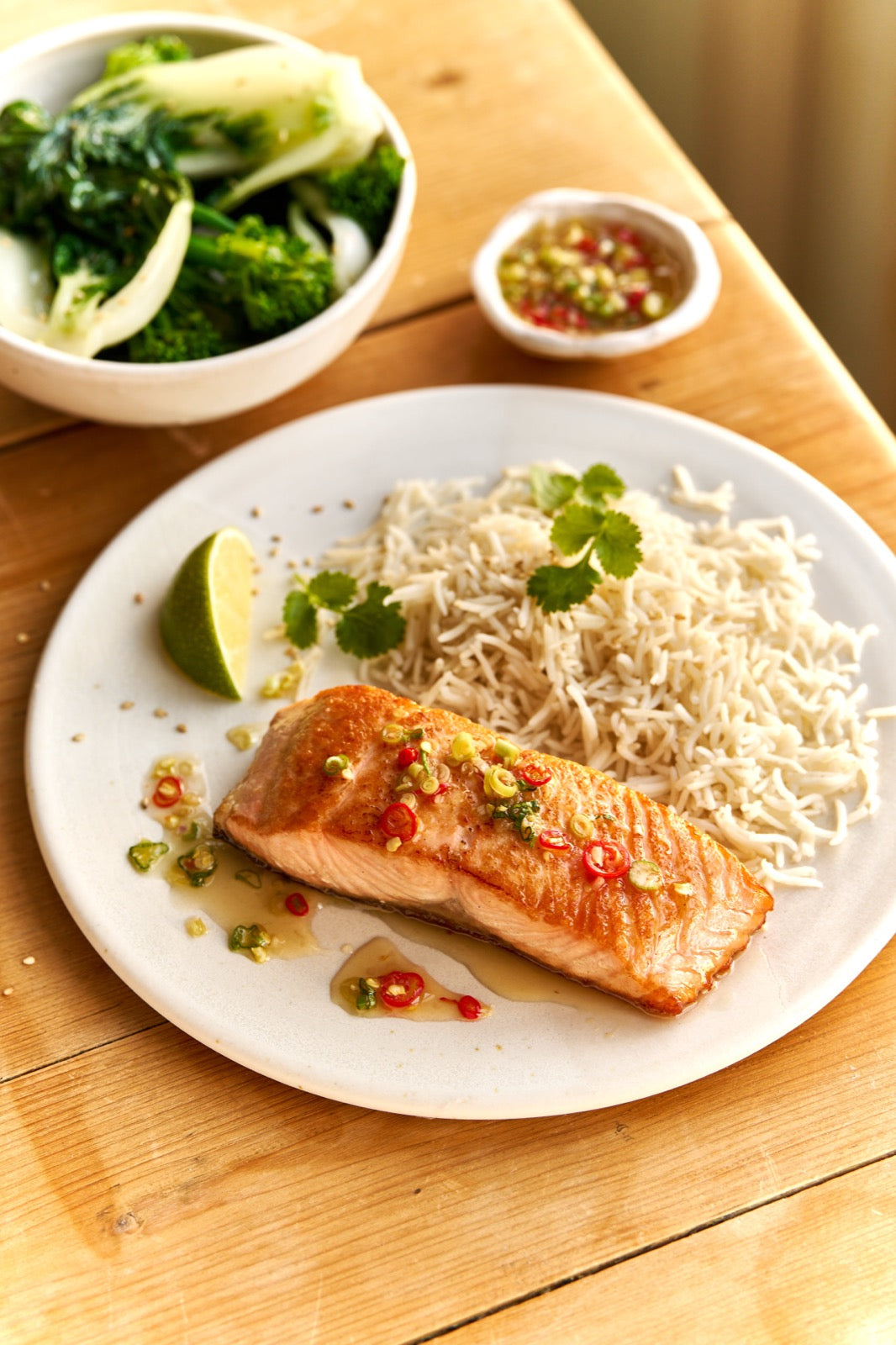 A portion of Salmon from Rockfish Online Seafood Market cooked on a plate next to some rice.
