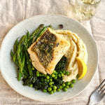 A portion of Hake fillet from Rockfish Online Seafood Market cooked on  plate with a side of mash and some greens.