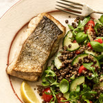 A portion of Coley fillet from Rockfish Online Seafood Market cooked on a plate next to a healthy salad.