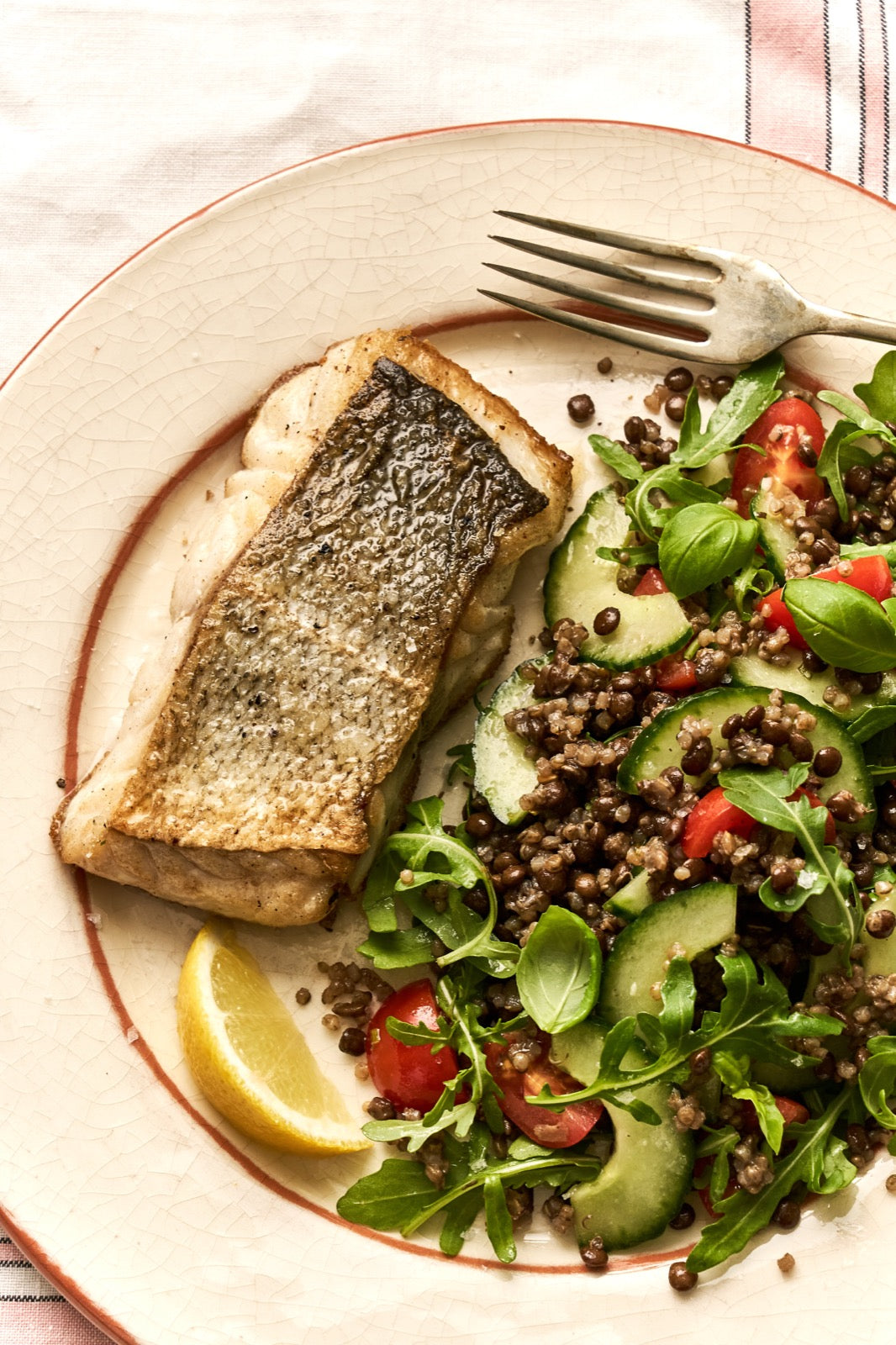 A portion of Coley fillet from Rockfish Online Seafood Market cooked on a plate next to a healthy salad.