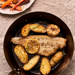 A portion of megrim sole from Rockfish in a pan with some potatoes and a side of carrots
