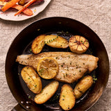 A portion of megrim sole from Rockfish in a pan with some potatoes and a side of carrots