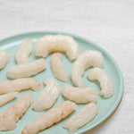 Langoustine tails out of the shell on a plate.