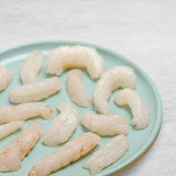 Langoustine tails out of the shell on a plate.