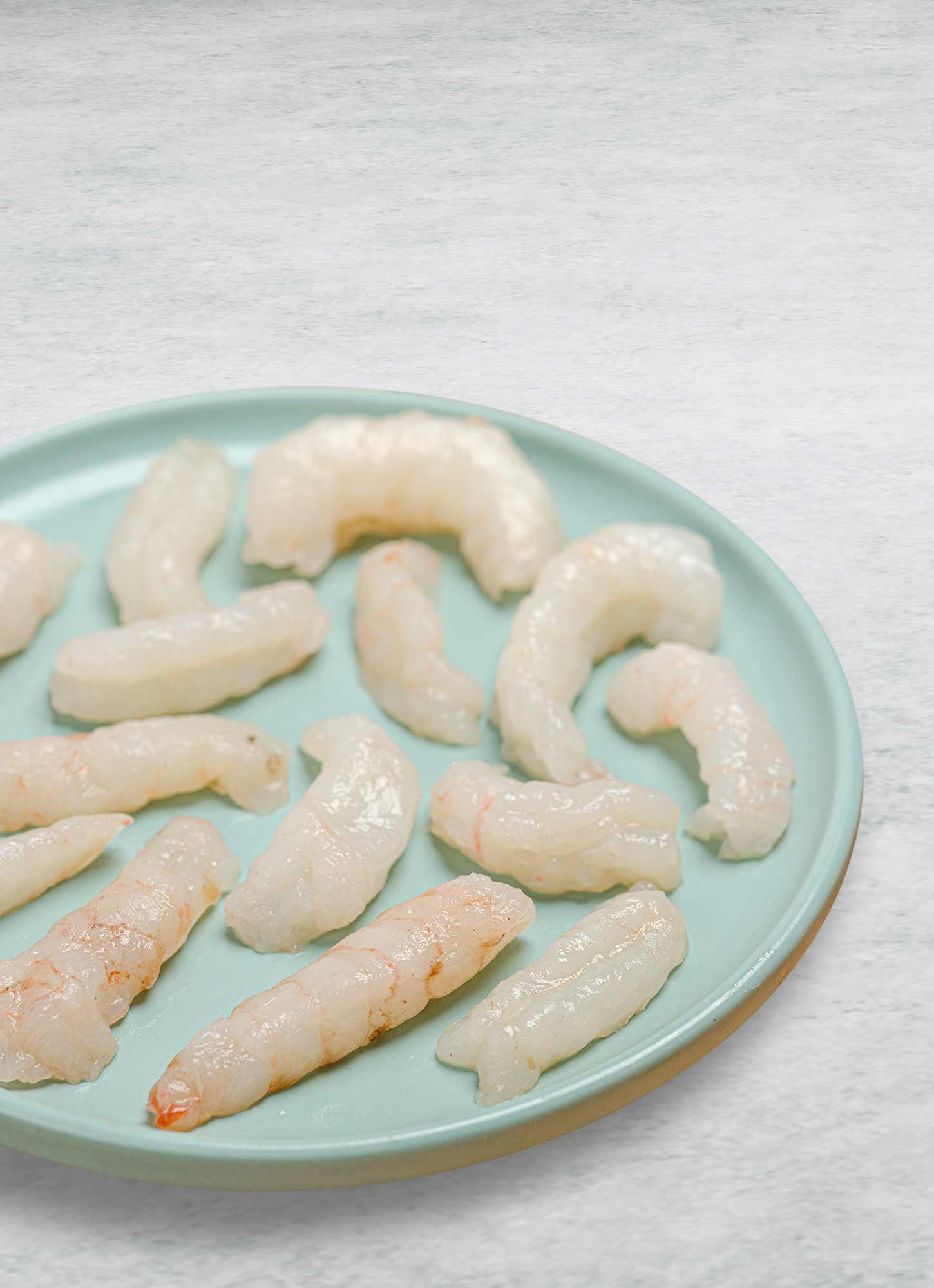 Langoustine tails out of the shell on a plate.