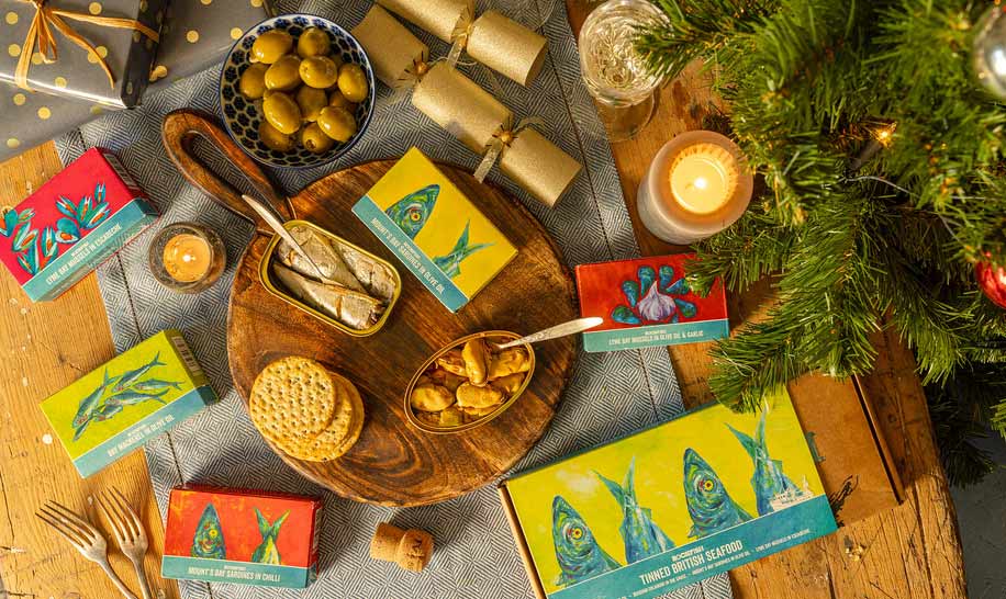 Rockfish tinned fish layer out on a festive looking table with Christmas tree and presents 